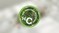 A creen circle on white blurry background featuring the text "with traceable biocontent" in smaller and "14 C" in bigger letters.