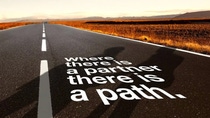 A long, empty road at sunset, surrounded by dry grass. The words "Where there is a partner, there is a path" overlay the road.