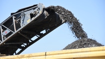 Conveyor belt unloading coal onto a mound against a clear blue sky. Conveyor belt unloading coal onto a mound against a clear blue sky.