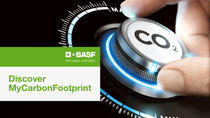 A hand adjusts a dial labeled "CO2" with glowing blue accents. The image features BASF branding and the text "Discover MyCarbonFootprint" on a green and white background.