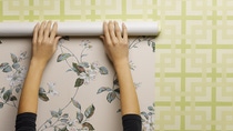 Woman wallpapering wall, close-up