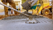 Construction workers are spreading cement mixture on the ground
  Construction workers are spreading cement mixture on the ground