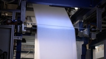Nonwoven fabric is running through a coating machine that applies acResin©  directly on the substrate.