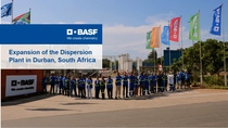 Thumbnail of a Video: BASF team standing at the Durban plant entrance with company flags, highlighting the expansion of the dispersion plant in South Africa.