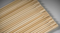 The photography shows a row of precisely arranged chopsticks.