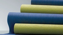 Several rolls of nonwoven wall coverings in green and blue. 