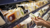 Woman buying cheese ina supermarket