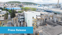 Aerial view of the Dilovasi production site in Turkey with numerous silos and buildings. The foreground has a "Press Release" banner. Cityscape and hills in the background. Aerial view of the Dilovasi production site in Turkey with numerous silos and buildings. The foreground has a "Press Release" banner. Cityscape and hills in the background.