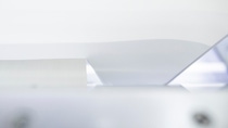 Close-up of a modern, sleek white printer feeding glossy paper. Close-up of a modern, sleek white printer feeding glossy paper.