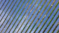 Aerial view of solar farm, with solar panel rows running diagonally from the lower left to the upper right of the image.