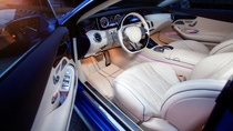 Luxurious car interior featuring white leather seats, a sleek dashboard with glowing gauges, and ambient lighting. Luxurious car interior featuring white leather seats, a sleek dashboard with glowing gauges, and ambient lighting.