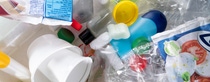A chaotic pile of colorful plastic waste including bottles, caps, packaging, and containers. A chaotic pile of colorful plastic waste including bottles, caps, packaging, and containers.