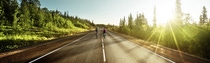 Picture of a road with two people riding bikes in the background Picture of a road with two people riding bikes in the background