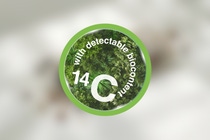 A creen circle on white blurry background featuring the text "with traceable biocontent" in smaller and "14 C" in bigger letters.
