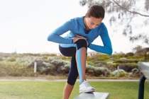 Sporty young woman stretching in the park
