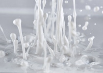 Splashing white liquid creates dynamic droplets and streams.
