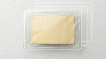 Transparent PET/PE packaging tray with slices of cheese, with added white lines indicating the different material layers